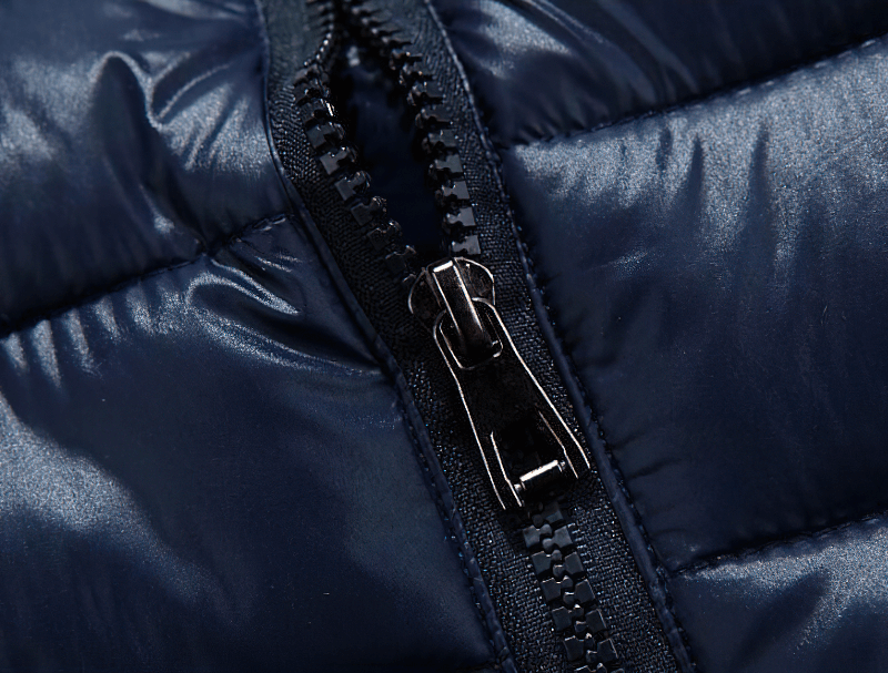 Close-up of a navy thermal vest zipper, showing detailed stitching and shiny polyester fabric.